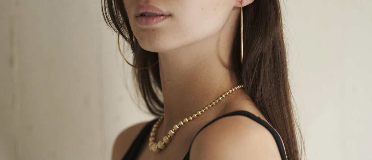 woman with gold hoop earrings and necklace